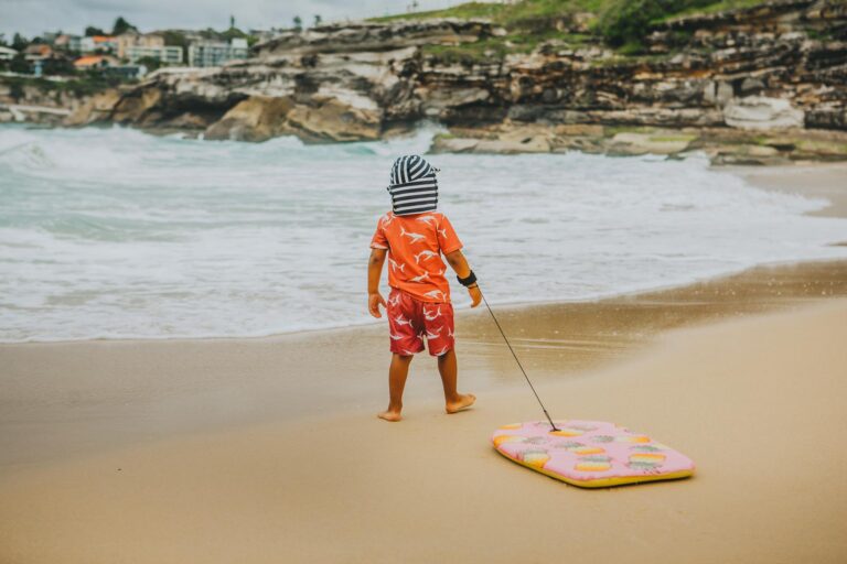 Todler at the beach with boogie board